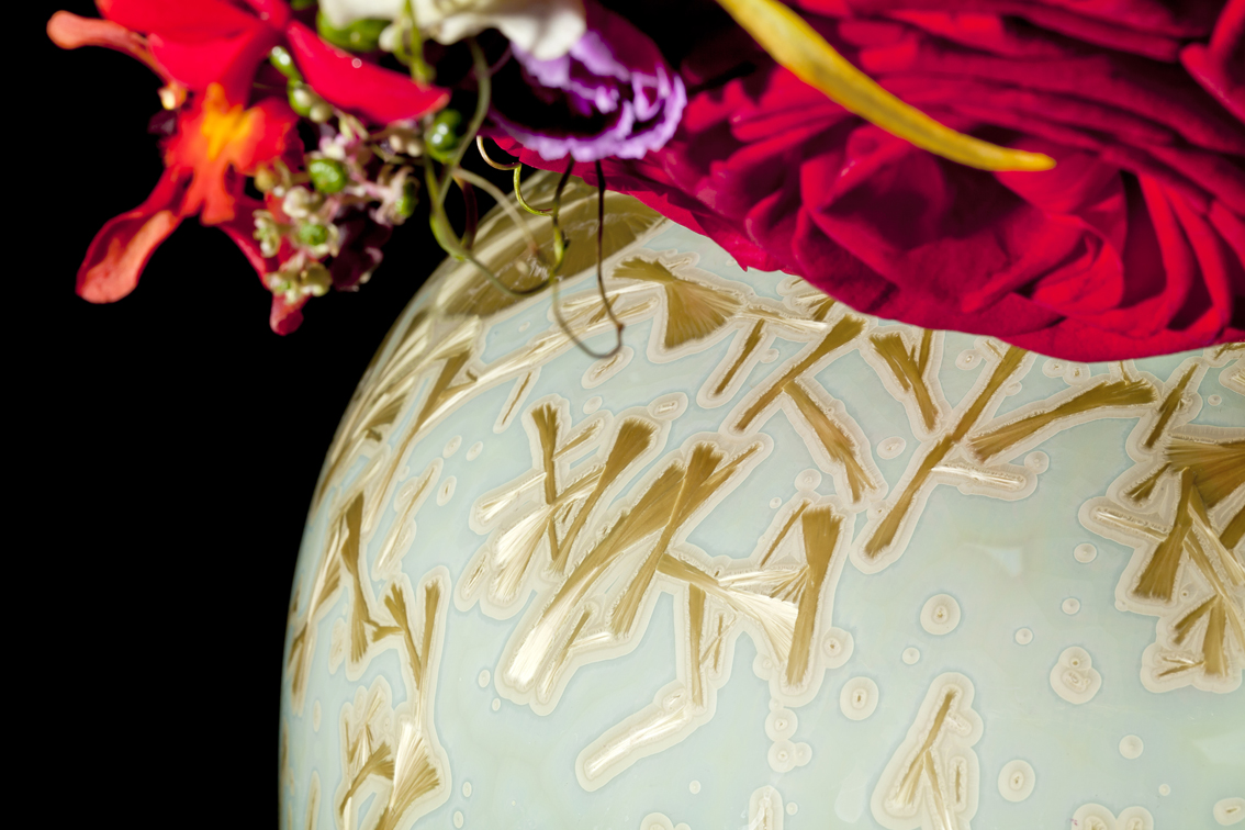 Vase mit goldenen Kristallen, gefüllt mit roten und bunten Blumen. Fürstenberg Porzellan.