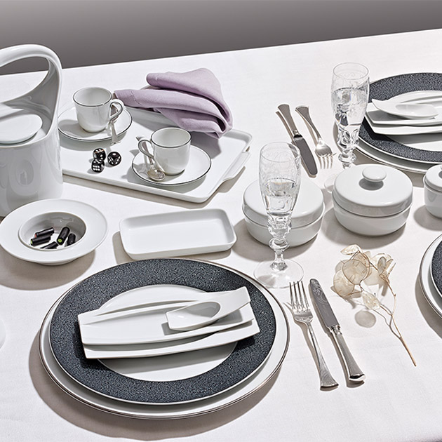 Elegantes weißes Geschirr auf gedecktem Tisch mit Gläsern und Besteck arrangiert. Fürstenberg Porzellan.