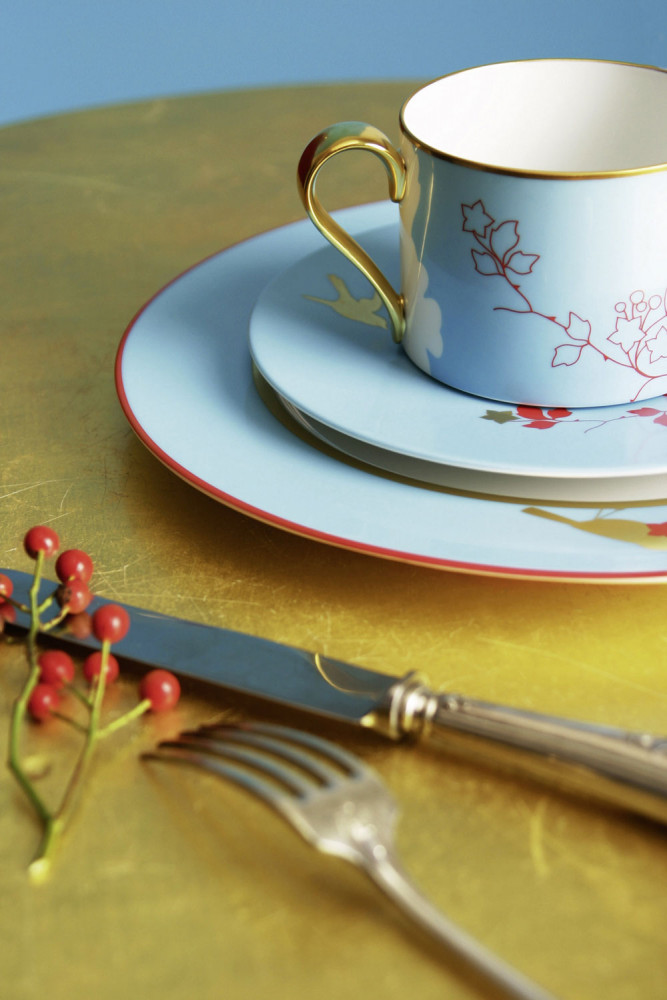 Tasse und Teller auf goldener Tischoberfläche, verziert mit floralem Muster. Fürstenberg Porzellan.