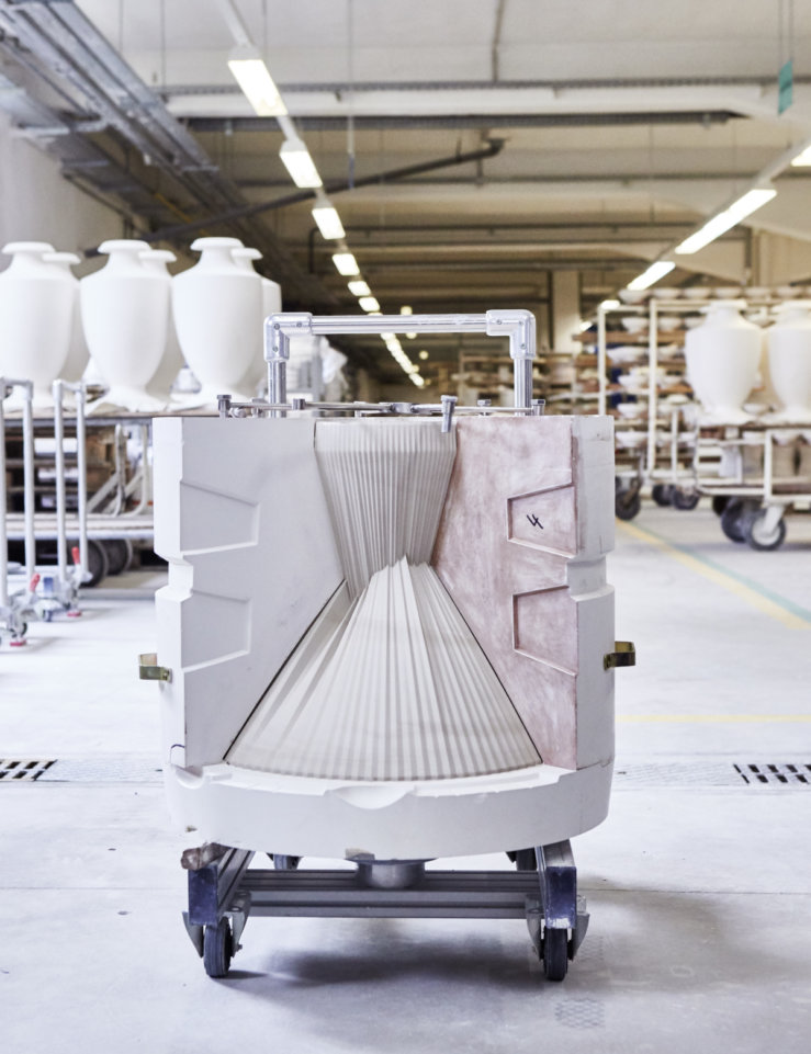 Gipsform auf Rollen, geöffnet in einer Fabrikhalle, Vasen im Hintergrund. Fürstenberg Porzellan.