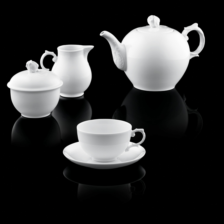 Weiße Porzellan-Teekanne, Milchkanne, Zuckerdose und Tasse auf schwarzem Hintergrund. Fürstenberg Porzellan.