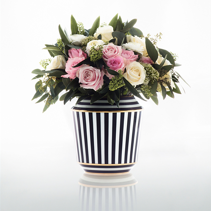 img2_va1795215705_vase_luna__schwarz_gold Schwarz-weiß gestreifte Vase, gefüllt mit rosa und weißen Rosen, grünes Laub. Fürstenberg Porzellan.