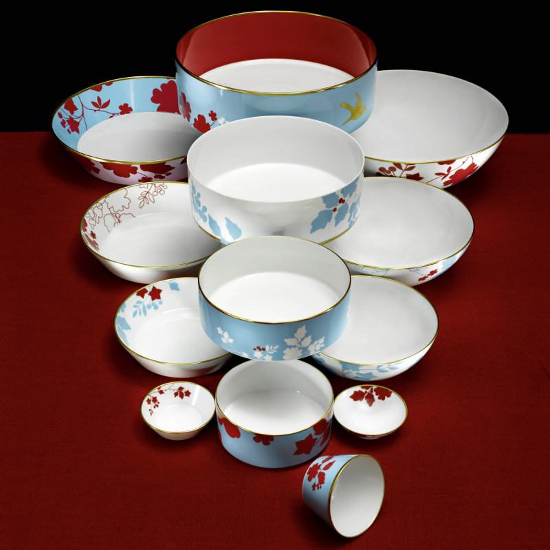 img2_ms2006165700_schale_m Verschiedene Porzellanschalen mit buntem Blumenmuster stapeln sich auf rotem Untergrund. Fürstenberg Porzellan.