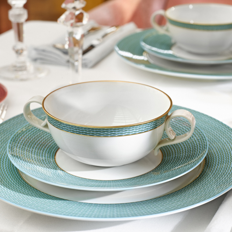 img2_un2011205904_suppenuntertasse Weiße Suppentasse mit blauem Muster und Goldrand auf gedecktem Tisch. Fürstenberg Porzellan.