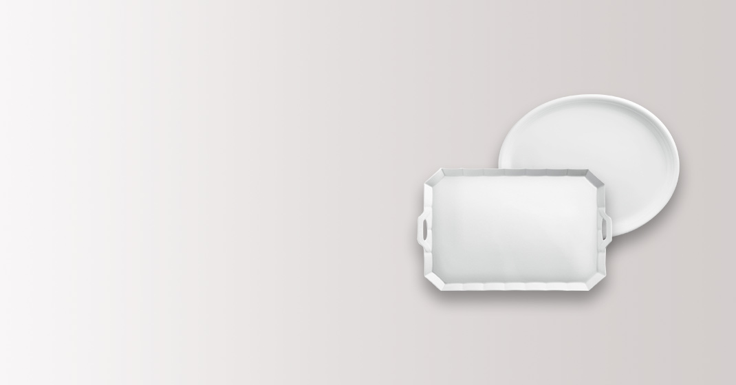 Zwei weiße Porzellantabletts, eines rechteckig und eines rund, auf grauem Hintergrund. Fürstenberg Porzellan.