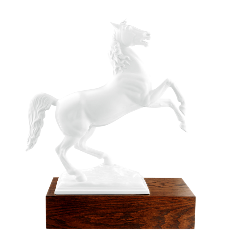 Porzellanfigur eines steigenden Pferdes auf einem hölzernen Sockel.